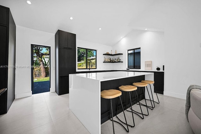 kitchen featuring a center island, a kitchen bar, and lofted ceiling