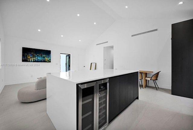 kitchen with high vaulted ceiling, a large island, and wine cooler