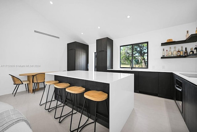 kitchen featuring a kitchen breakfast bar, a kitchen island, lofted ceiling, and paneled built in refrigerator