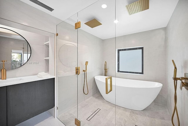 bathroom featuring vanity, tile walls, and shower with separate bathtub