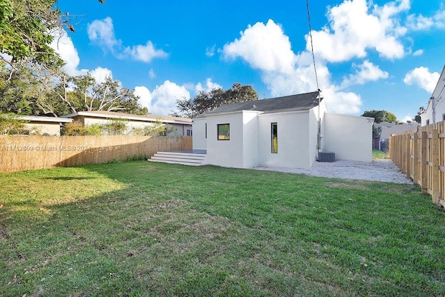 rear view of house with a yard and central AC