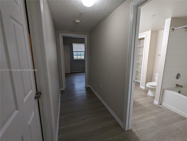 corridor featuring hardwood / wood-style floors and a textured ceiling