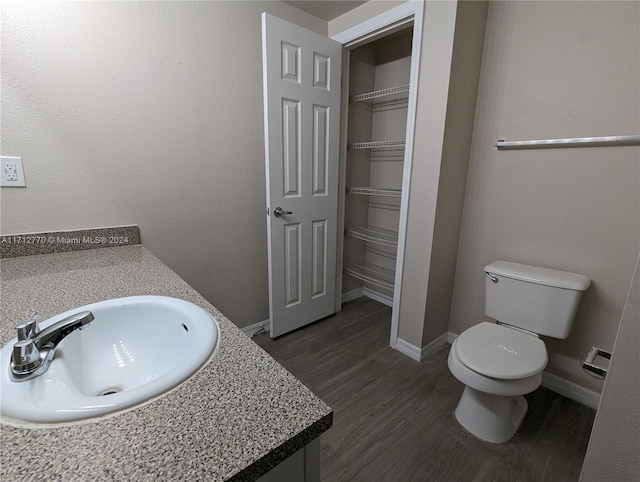 bathroom with hardwood / wood-style flooring, vanity, and toilet