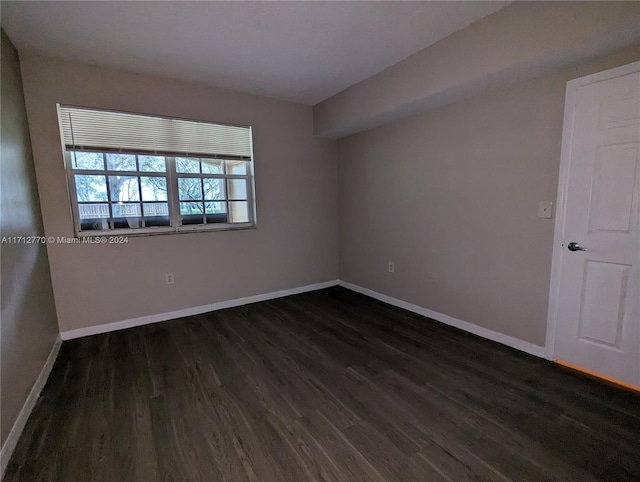 spare room featuring dark wood-type flooring