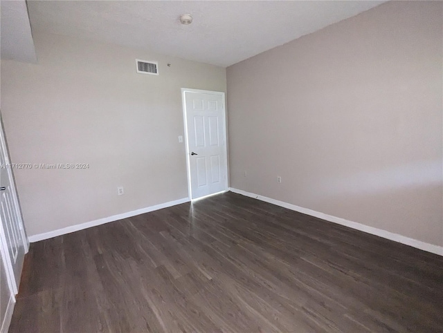 spare room with dark wood-type flooring