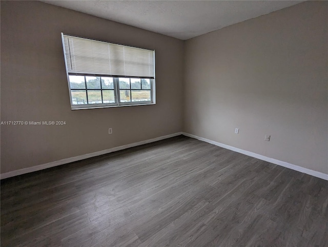 spare room featuring a textured ceiling and dark wood-type flooring