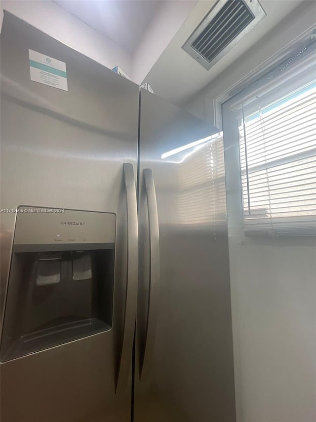 interior details featuring stainless steel refrigerator with ice dispenser