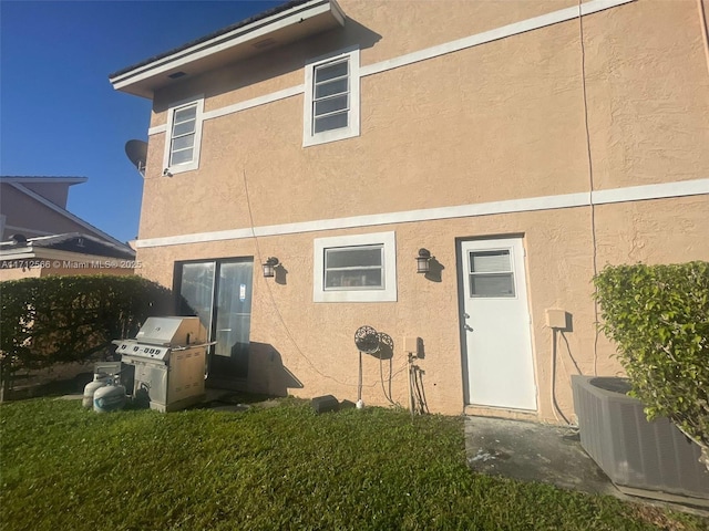 4075 Coral Springs Dr Unit 5, Coral Springs, FL 33065 - back of house with a lawn, central air condition unit, and stucco siding