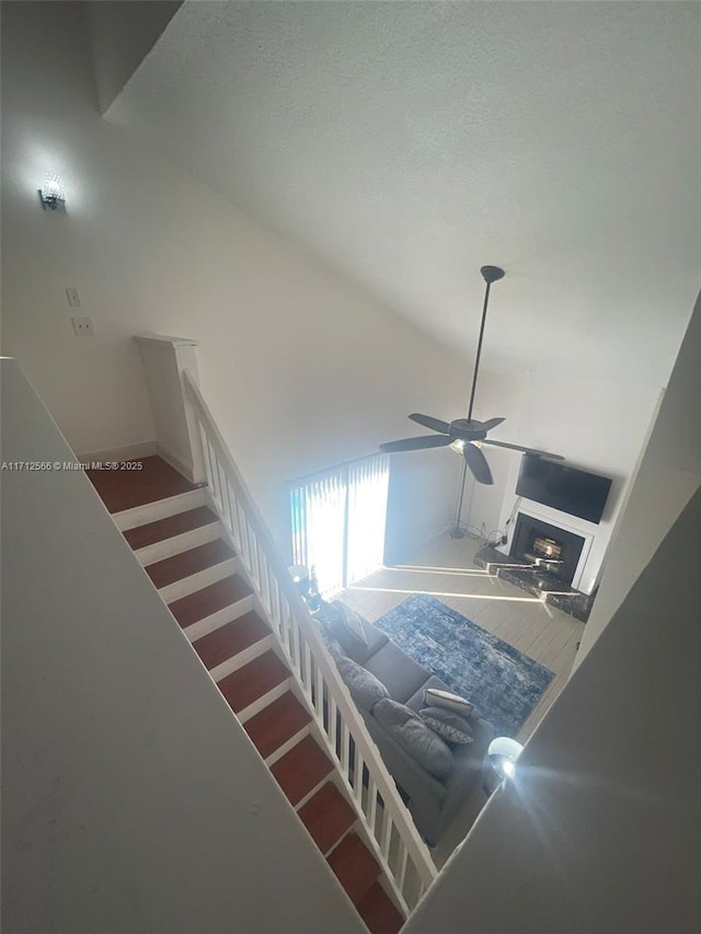 4075 Coral Springs Dr Unit 5, Coral Springs, FL 33065 - stairway featuring a ceiling fan, a textured ceiling, and a fireplace with raised hearth