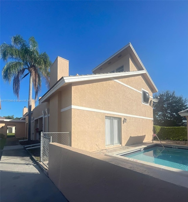 rear view of property with a community pool