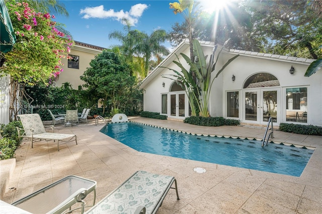 view of swimming pool with an outbuilding, french doors, and a patio area