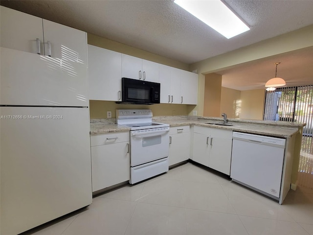 kitchen with white appliances, white cabinets, sink, hanging light fixtures, and a textured ceiling