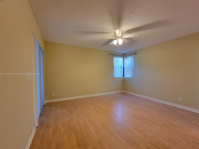 empty room with ceiling fan, light hardwood / wood-style floors, and a textured ceiling