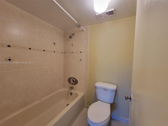 bathroom featuring tile patterned flooring, tiled shower / bath combo, and toilet