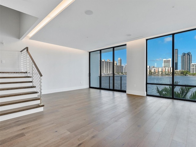 unfurnished living room featuring hardwood / wood-style flooring and a wall of windows