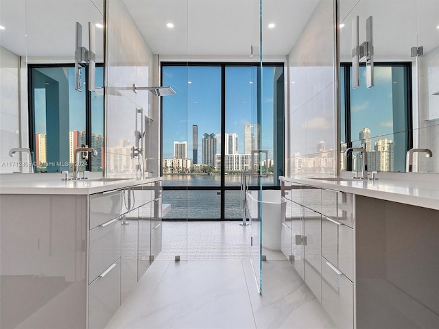 bathroom with vanity, a wall of windows, and a tub