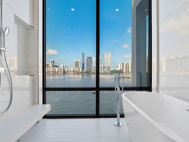 bathroom with tile patterned flooring, a water view, and a bathtub