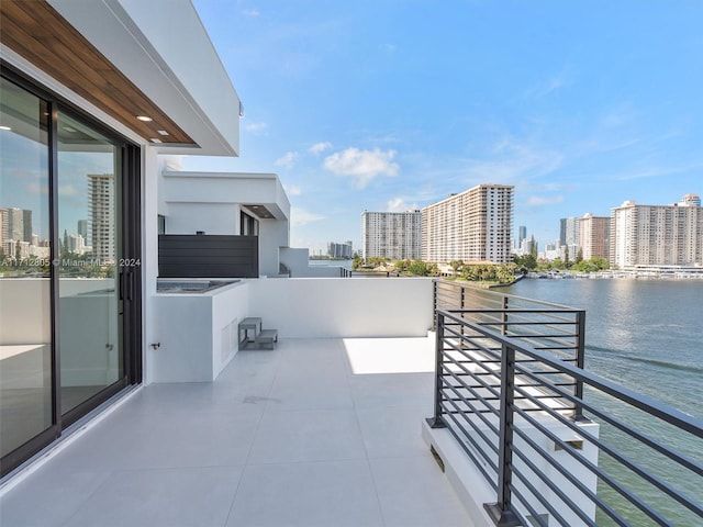 view of patio / terrace with a balcony and a water view