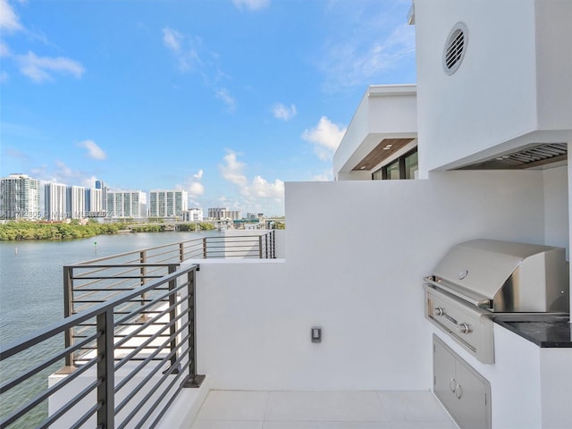 view of patio / terrace with area for grilling, a balcony, and a water view