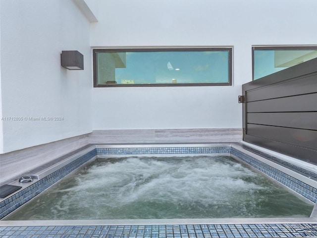 view of pool with a hot tub