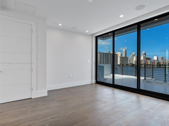 spare room with hardwood / wood-style flooring and a wall of windows