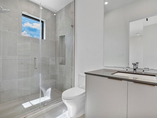 bathroom featuring tile patterned floors, vanity, toilet, and walk in shower