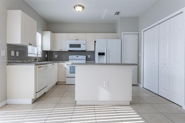 kitchen with white cabinetry, sink, backsplash, white appliances, and a kitchen island