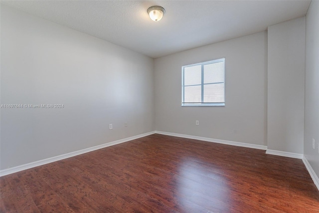 spare room featuring dark wood-type flooring