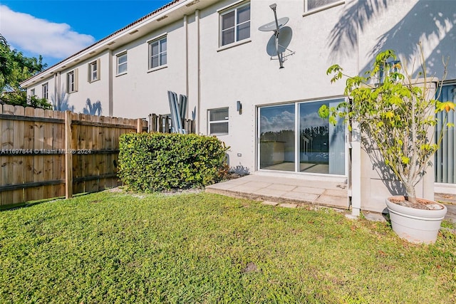 rear view of property featuring a lawn