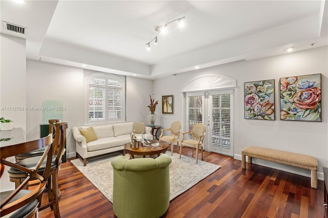 living room with track lighting, dark hardwood / wood-style flooring, and french doors