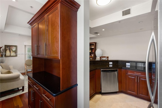 kitchen featuring dark stone countertops, light wood-type flooring, and appliances with stainless steel finishes