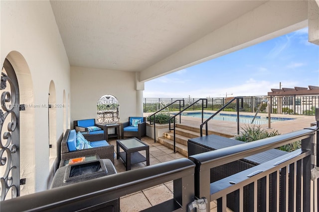 view of patio featuring a fenced in pool and an outdoor living space with a fire pit