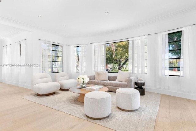 living room with crown molding, a healthy amount of sunlight, and wood-type flooring