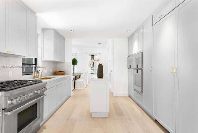 kitchen with white cabinets, sink, and stainless steel range