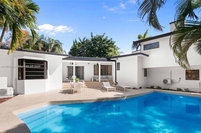 rear view of property with ac unit and a patio