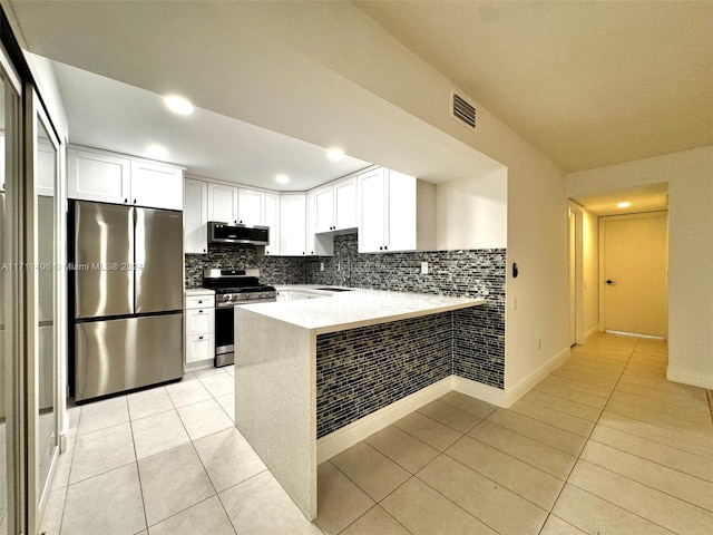 kitchen featuring kitchen peninsula, appliances with stainless steel finishes, white cabinets, and sink