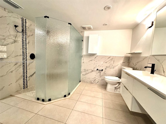 bathroom with vanity, tile patterned flooring, toilet, tile walls, and an enclosed shower