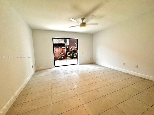 tiled spare room featuring ceiling fan