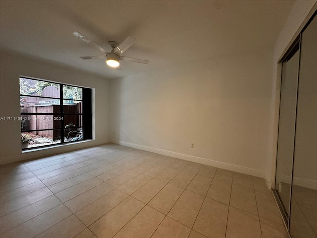 tiled empty room featuring ceiling fan