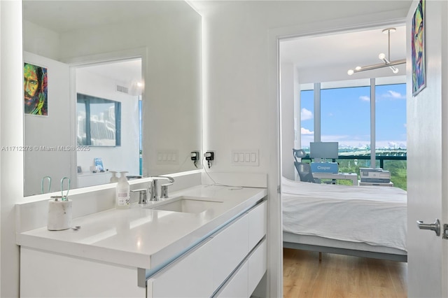 bathroom with hardwood / wood-style floors, vanity, and a chandelier