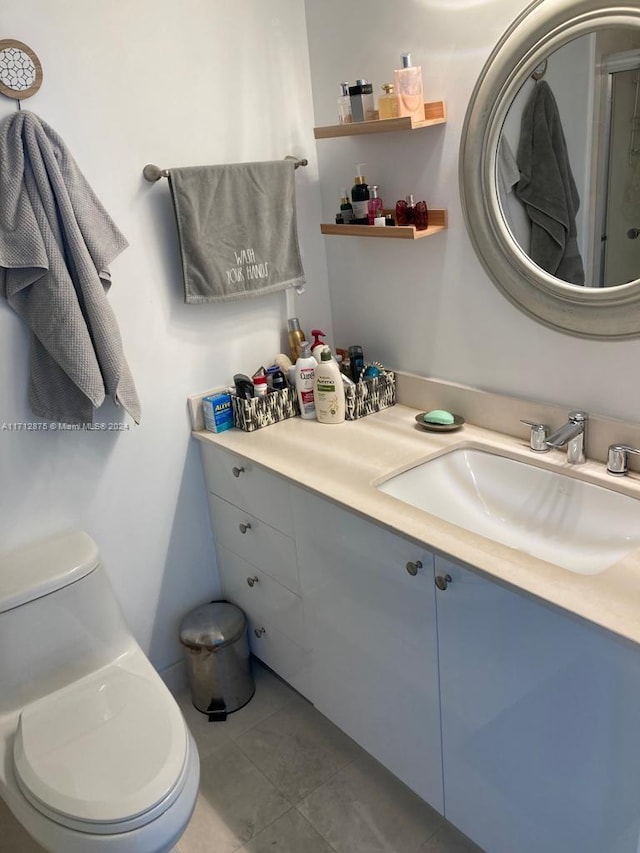 bathroom featuring tile patterned flooring, vanity, and toilet