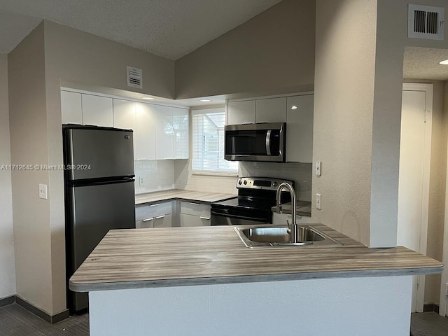 kitchen with white cabinets, sink, kitchen peninsula, and stainless steel appliances