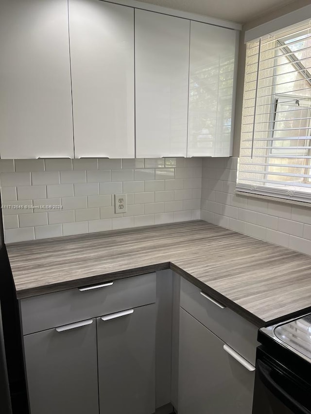 kitchen with backsplash and wooden counters