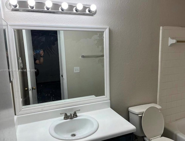 full bathroom featuring washtub / shower combination, vanity, and toilet