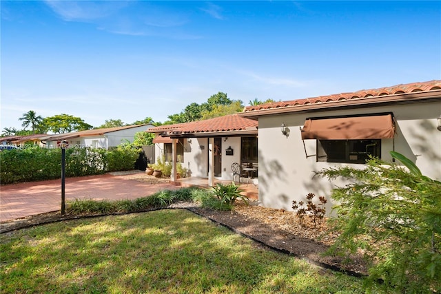 view of front of home with a front lawn and a patio