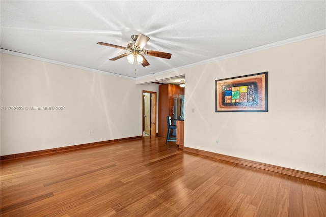 unfurnished room featuring ceiling fan, wood-type flooring, a textured ceiling, and ornamental molding