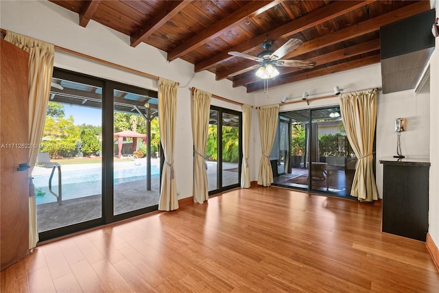 spare room with beamed ceiling, ceiling fan, wood ceiling, and light hardwood / wood-style flooring