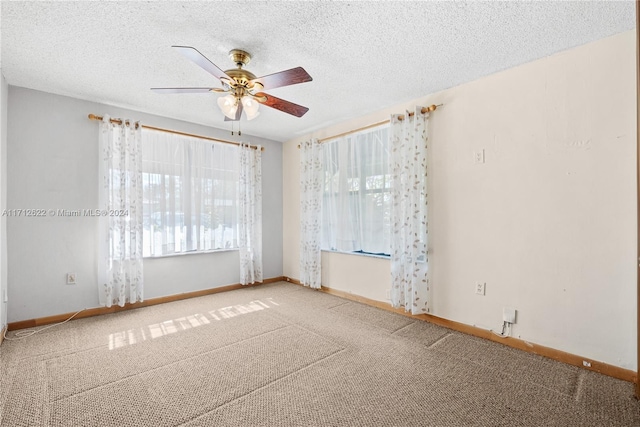 empty room with carpet flooring, ceiling fan, and a textured ceiling