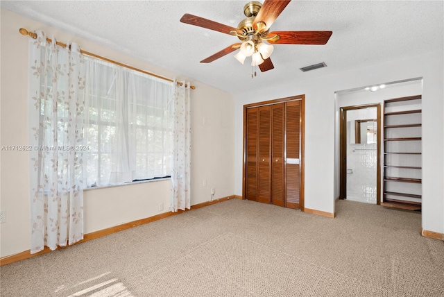 unfurnished bedroom featuring ceiling fan, a closet, carpet floors, and a textured ceiling