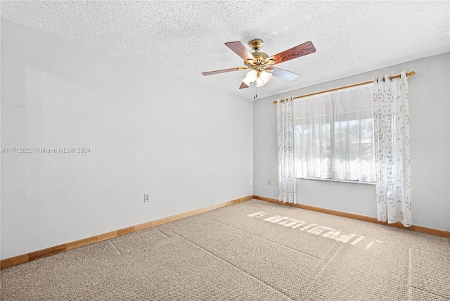 carpeted spare room with ceiling fan and a textured ceiling